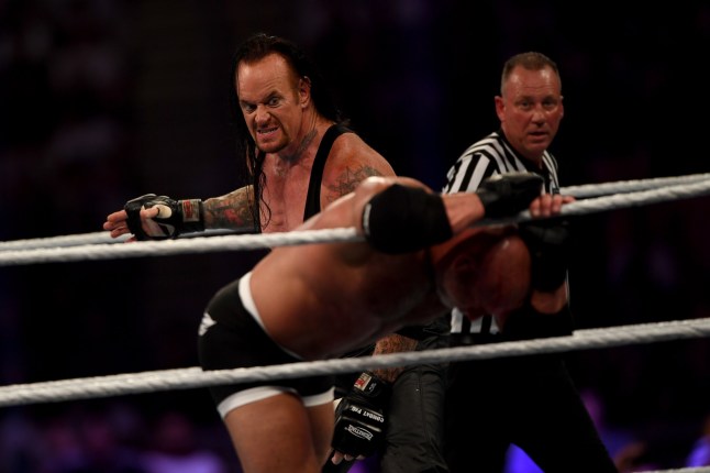 World Wrestling Entertainment star The Undertaker (L) competes against Goldberg (C) during the World Wrestling Entertainment (WWE) Super Showdown event in the Saudi Red Sea port city of Jeddah late on January 7, 2019. (Photo by Amer HILABI / AFP) (Photo credit should read AMER HILABI/AFP via Getty Images)