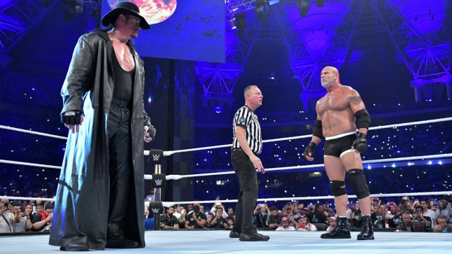 Mike Chioda stands with The Undertaker and Goldberg during WWE Super ShowDown
