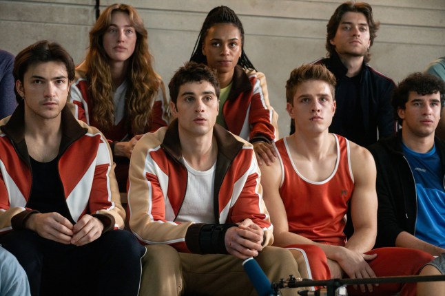 Characters in Olympo wearing sports gear sat together on benches