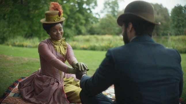 The Gilded Age Season 3 still of a woman in a purple dress holding the hand of a man with his back turned to us